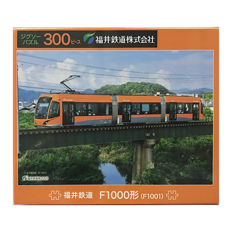 鉄橋を走るオレンジ色の電車「フクラム」が青空に鮮やかに映える構図です。